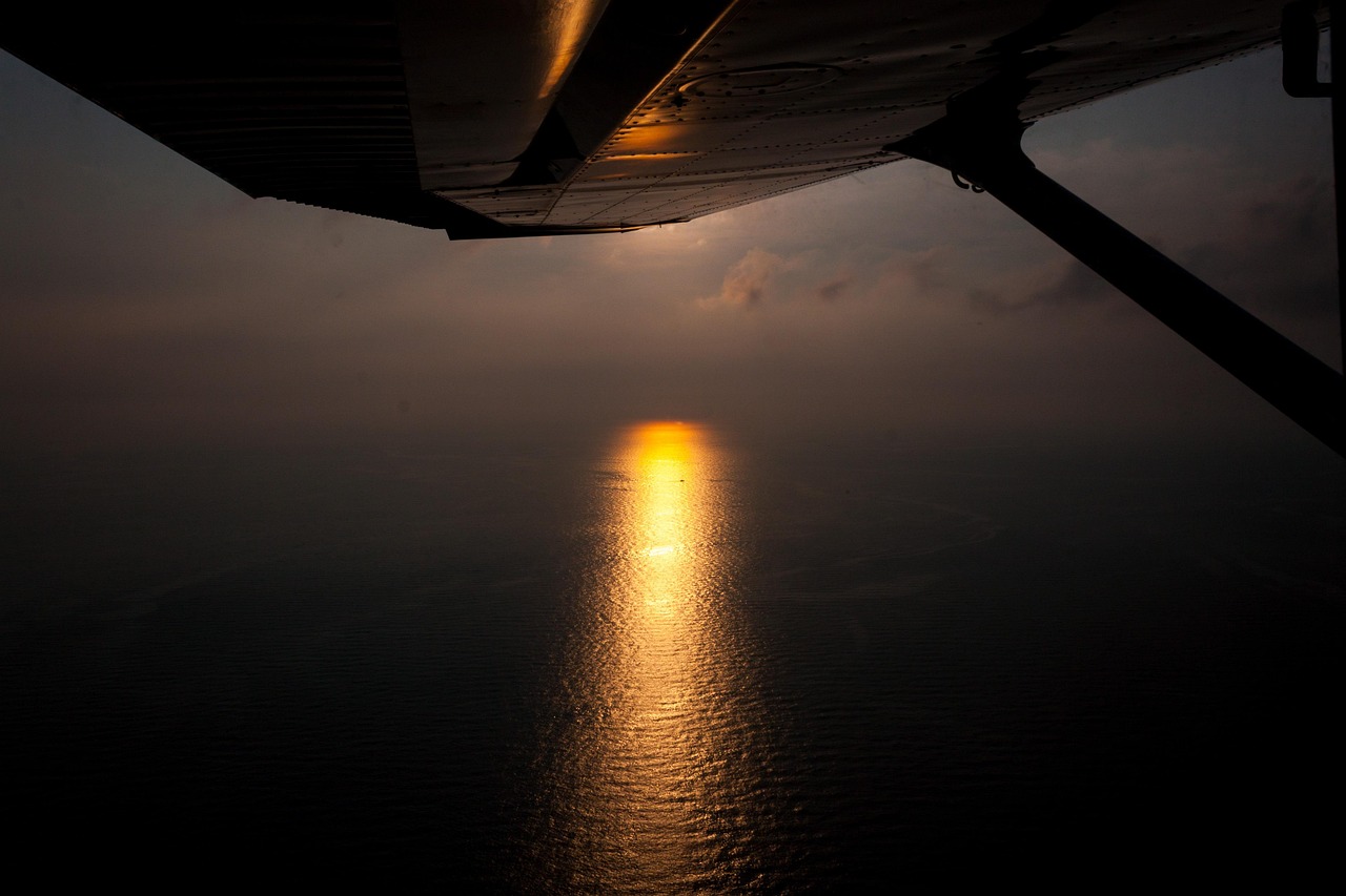Canada eTA for Australians: aircraft wing above a dark sea with the setting sun reflected on the water