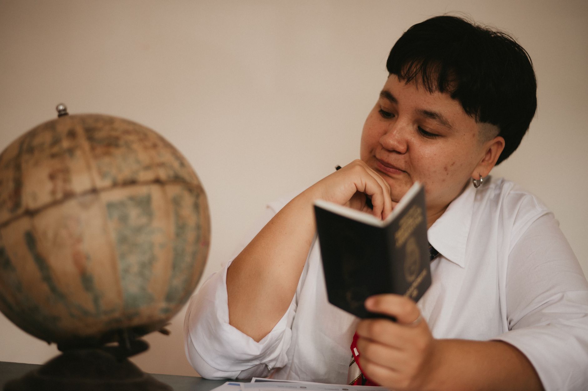 A traveller reading a passport beside a globe