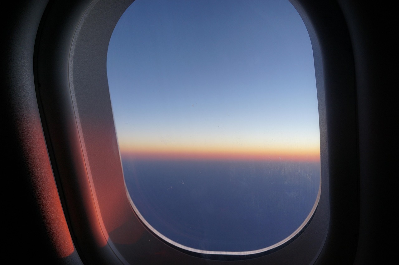 Canada eTA for Mexican citizens: warm dawn light on the horizon through an airplane window