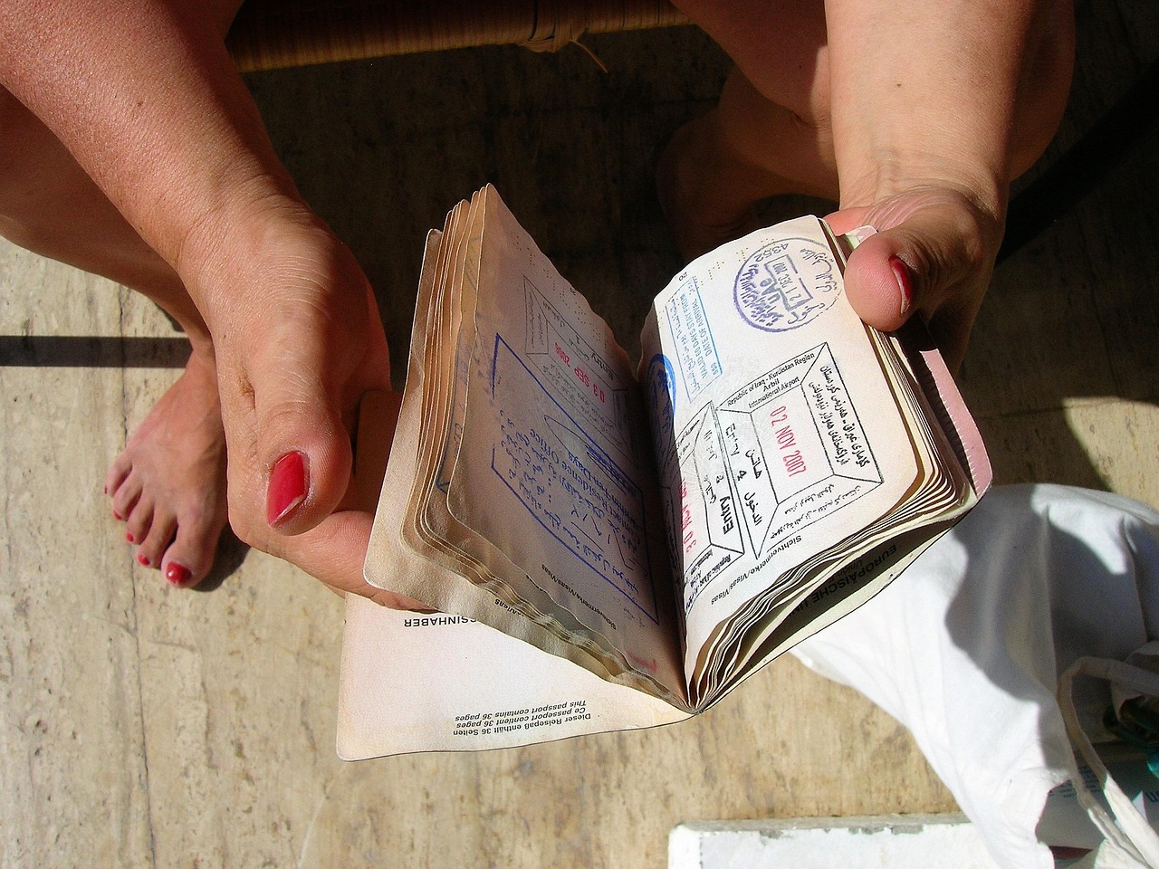 Canada eTA: hands holding open a passport showing multiple visa stamps