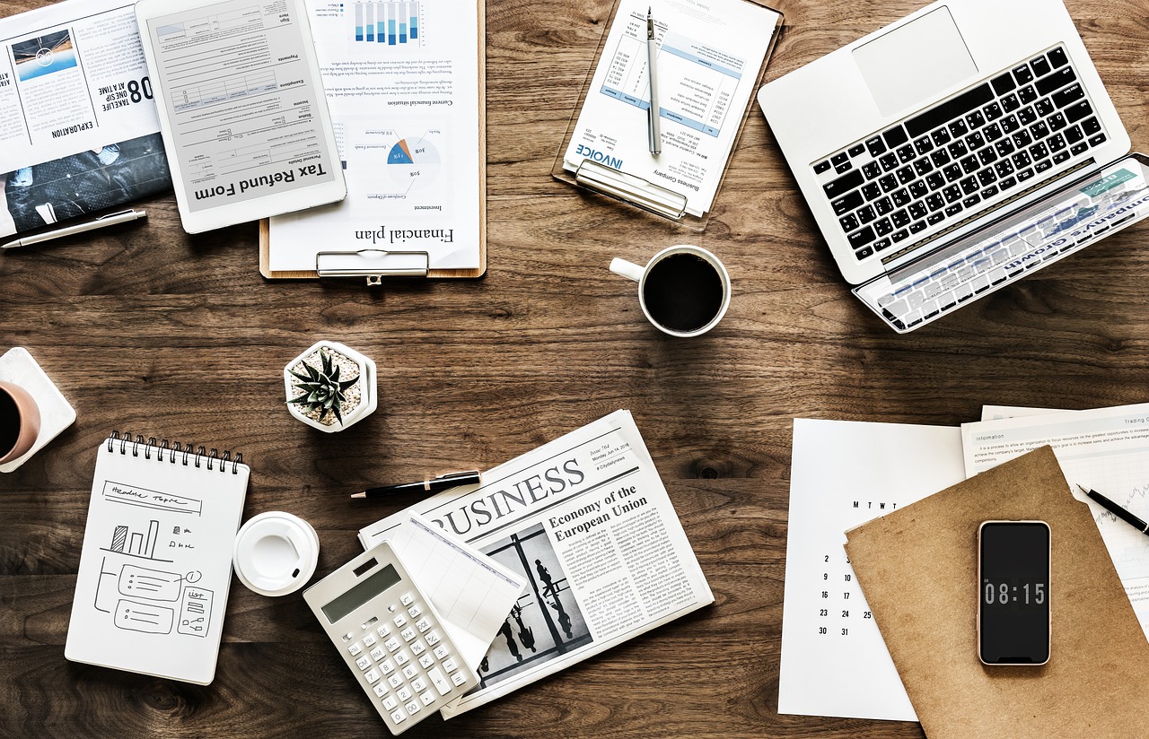 Government of Canada eTA Application: The Official Website and How to Apply: wooden desk with laptop, notebook and papers seen from above