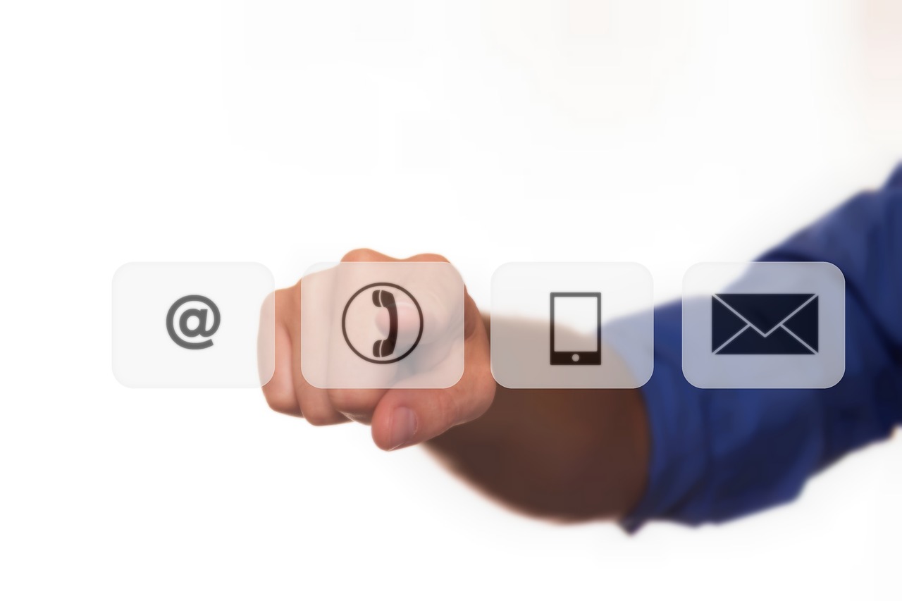 Hand pressing a virtual button with a telephone icon, with email and message icons nearby.