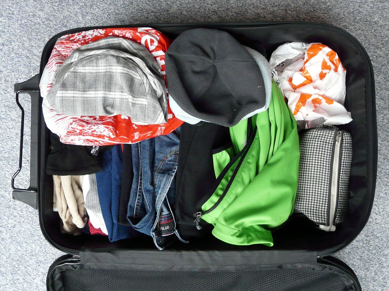 What Is a Canada eTA: open black suitcase packed with folded clothes and a toiletry bag